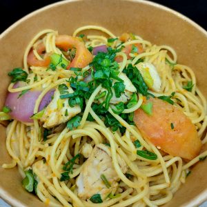 Tallarin Saltado ( pasta al wok con cortes de pescado , cebolla morada, aji amarillo,cebollin con sazon Tako )